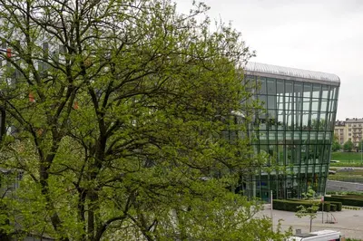 a tree in front of a large glass building at Comfort Apartment in great location in Kraków