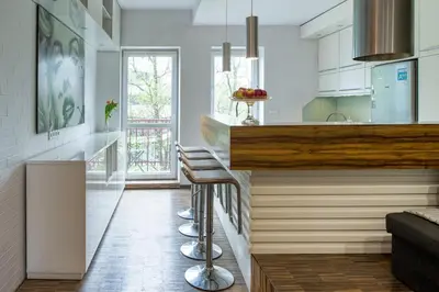a kitchen with a bar with stools at a counter at Comfort Apartment in great location in Kraków