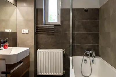 a bathroom with a shower and a sink and a bath tub at Comfort Apartment in great location in Kraków