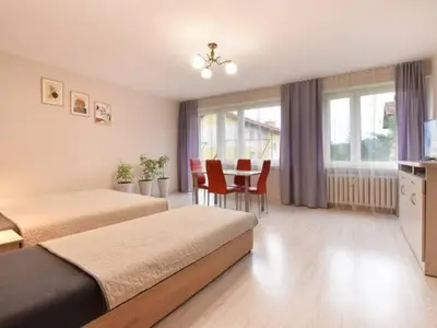 a hotel room with two beds and a table with chairs at Apartament Natalia in Wadowice