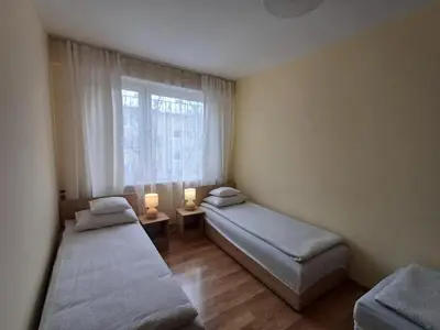 two beds in a small room with a window at Apartament Natalia in Wadowice