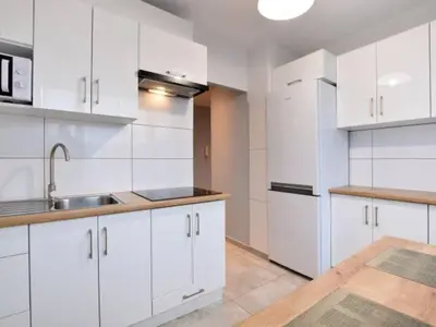 a white kitchen with white cabinets and a sink at Apartament Natalia in Wadowice
