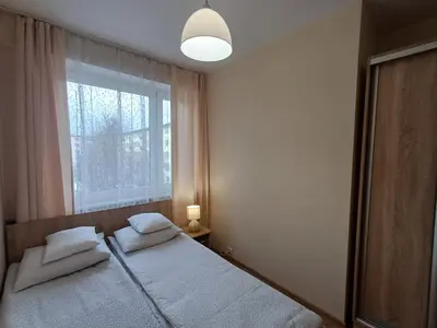 a bedroom with two beds and a window at Apartament Natalia in Wadowice