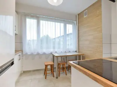 a kitchen with a table and chairs and a window at Apartament Natalia in Wadowice