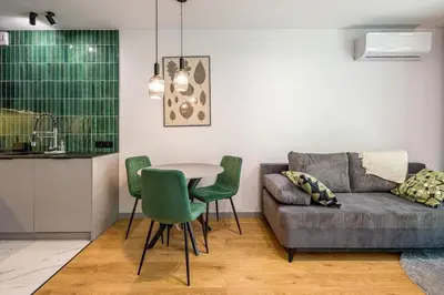 a living room with a couch and a table and chairs at High standard in top location in Kraków