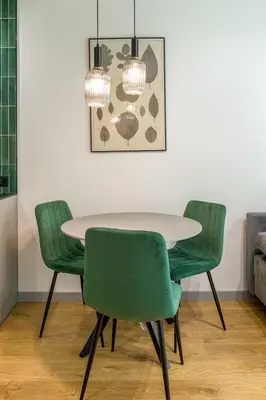 a dining room with a table and four green chairs at High standard in top location in Kraków