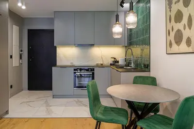 a kitchen with a table and green chairs at High standard in top location in Kraków