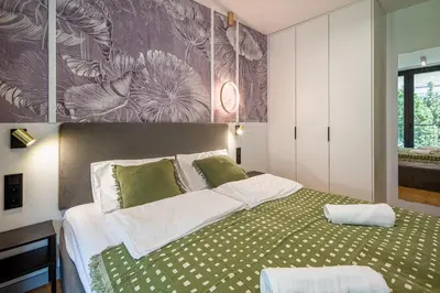 a bedroom with a large bed with green sheets at High standard in top location in Kraków