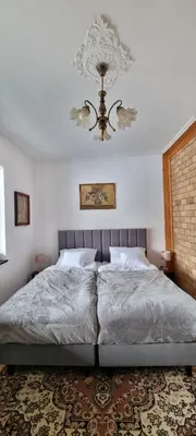 a bedroom with a large bed with a chandelier at Górnica apart in Andrychów