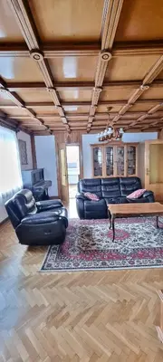 a living room with black leather furniture and a rug at Górnica apart in Andrychów