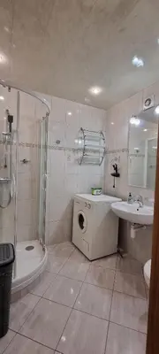 a bathroom with a shower sink and a washing machine at Górnica apart in Andrychów