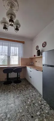 a kitchen with a refrigerator and a table in it at Górnica apart in Andrychów