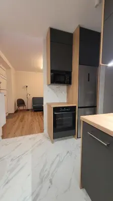 a kitchen with white marble floors and a refrigerator at Nowa Huta 12 in Kraków
