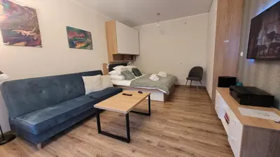 a living room with a blue couch and a bed at Nowa Huta 12 in Kraków