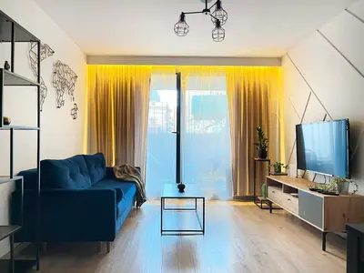 a living room with a blue couch and a tv at Apartment with Terrace and Two Bedrooms, Cracow Vistula Boulevards in Kraków
