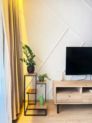 a living room with a tv and a desk with plants at Apartment with Terrace and Two Bedrooms, Cracow Vistula Boulevards in Kraków