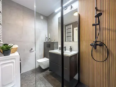 a bathroom with a shower and a toilet and a sink at Nowoczesny Apartament Pychowicka 3B in Kraków