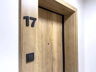 a wooden door with the number on it at Nowoczesny Apartament Pychowicka 3B in Kraków