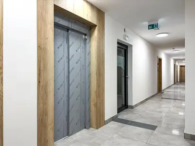 a hallway with a door in a building at Nowoczesny Apartament Pychowicka 3B in Kraków