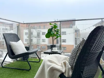 two chairs on a balcony with a view of a building at Krakowski zakątek- Apartament premium z garażem in Kraków
