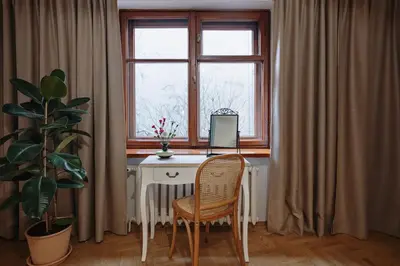 a desk with a computer and a chair in front of a window at Mikołajska Apartment 2 in Kraków