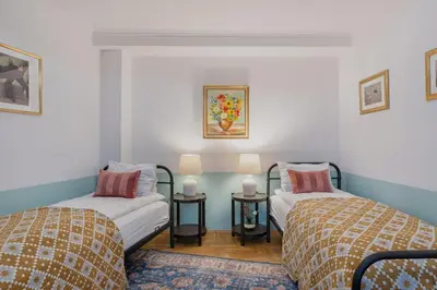 a room with two beds and two tables with lamps at Mikołajska Apartment 2 in Kraków