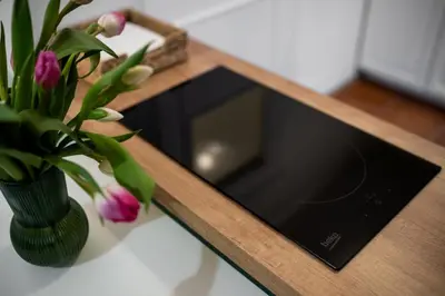 a table with a vase of flowers and a microwave at Mikołajska Apartment 2 in Kraków