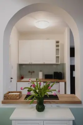 a vase of flowers on a counter in a kitchen at Mikołajska Apartment 2 in Kraków