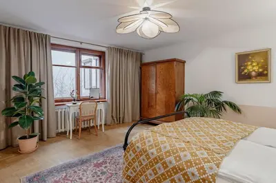 a bedroom with a bed and a table and a window at Mikołajska Apartment 2 in Kraków