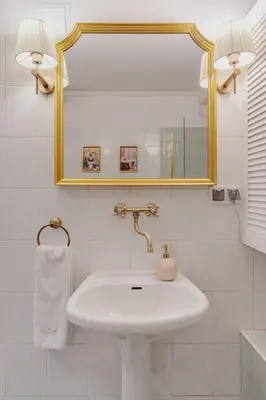 a white bathroom with a sink and a mirror at Mikołajska Apartment 2 in Kraków