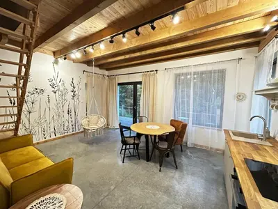 a kitchen and dining room with a table and chairs at Szumidomki strefa z jacuzzi sauna widok na potok las in Zawoja