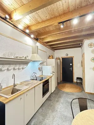 a kitchen with white appliances and a wooden ceiling at Szumidomki strefa z jacuzzi sauna widok na potok las in Zawoja