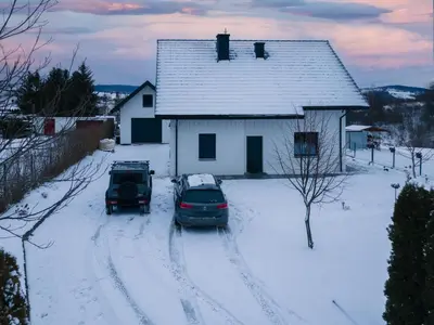 two cars parked in the snow in front of a house at ZinHouse Wojakowa in Wojakowa
