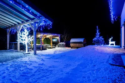 a yard covered in snow at night with christmas lights at ZinHouse Wojakowa in Wojakowa