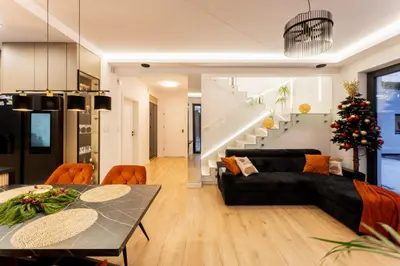 a living room with a black couch and a table at ZinHouse Wojakowa in Wojakowa