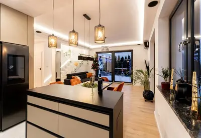 a kitchen with a island and a living room at ZinHouse Wojakowa in Wojakowa
