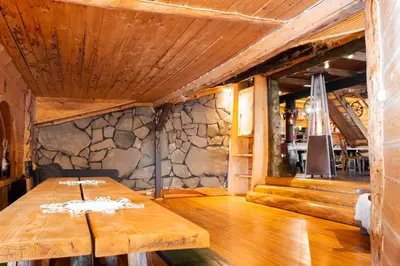 a wooden table in a room with a stone wall at Chata Gołębiówka in Rzyki