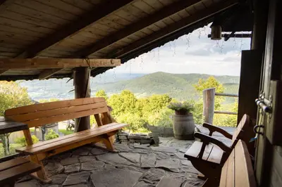 a porch with benches and a view of the mountains at Chata Gołębiówka in Rzyki