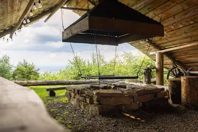a stone fire pit in a cabin with a grill at Chata Gołębiówka in Rzyki