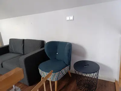 a living room with a blue chair and a couch at Bukszpanowa Alejka domek całoroczny, okolica Ojcowski Park Narodowy in Milonki
