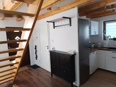 a kitchen with white cabinets and a black refrigerator at Bukszpanowa Alejka domek całoroczny, okolica Ojcowski Park Narodowy in Milonki