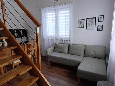 a living room with a couch and a staircase at Bukszpanowa Alejka domek całoroczny, okolica Ojcowski Park Narodowy in Milonki