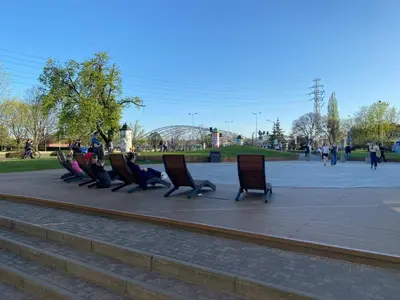 a row of chairs sitting in a park at Krakow Center - Chill Spot by the River in Kraków