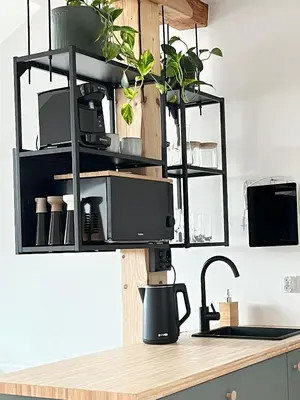a kitchen counter with black shelves and a microwave at Premium Jacuzzi with Air conditioning, Main Square Cracow in Kraków