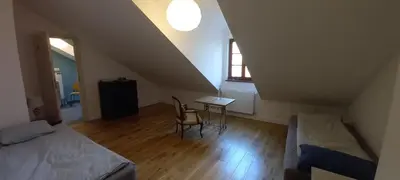 a attic bedroom with a bed and a desk and a window at Nowy Dwór w Goszycach in Goszyce
