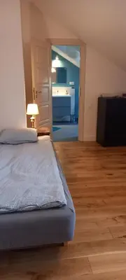 a bedroom with a bed and a living room at Nowy Dwór w Goszycach in Goszyce