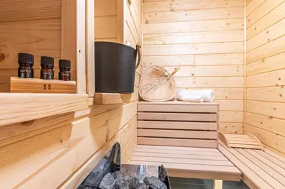 a wooden sauna with two bottles of essential oils at Solankowe Zacisze Żmiąca in Żmiąca