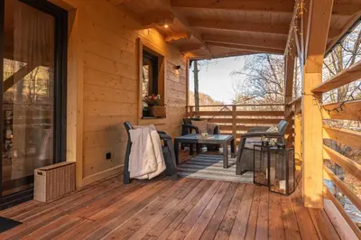a porch of a log cabin with a table and chairs at Solankowe Zacisze Żmiąca in Żmiąca