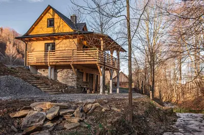 a large wooden house in the middle of a forest at Solankowe Zacisze Żmiąca in Żmiąca