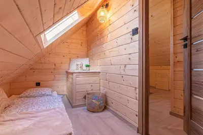 a bedroom with two beds in a wooden cabin at Solankowe Zacisze Żmiąca in Żmiąca